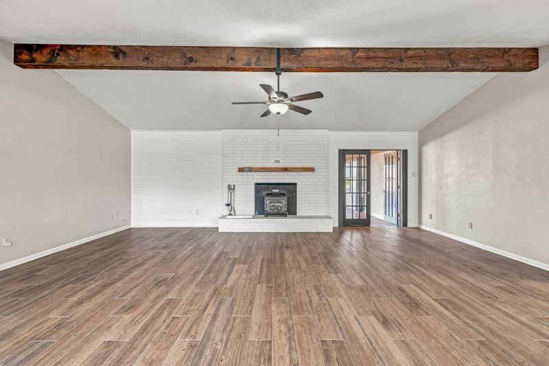 Living room facing the white brick fireplace with a wood-burning insert