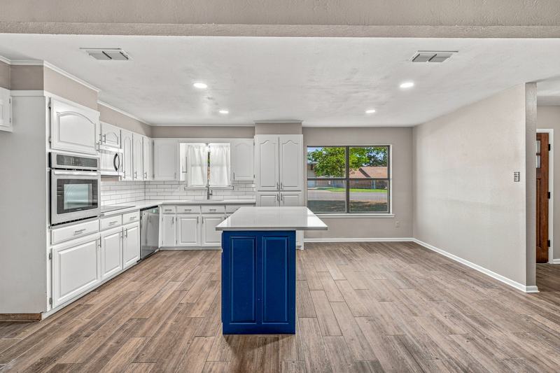Kitchen and dining space with the blue island and white countertops