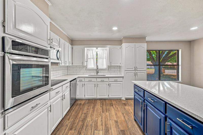 Kitchen with a stainless wall oven, microwave, and white cabinets