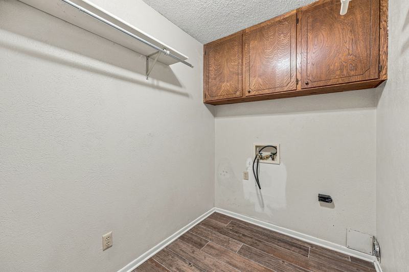 Laundry area with washer and dryer hookups and upper cabinets