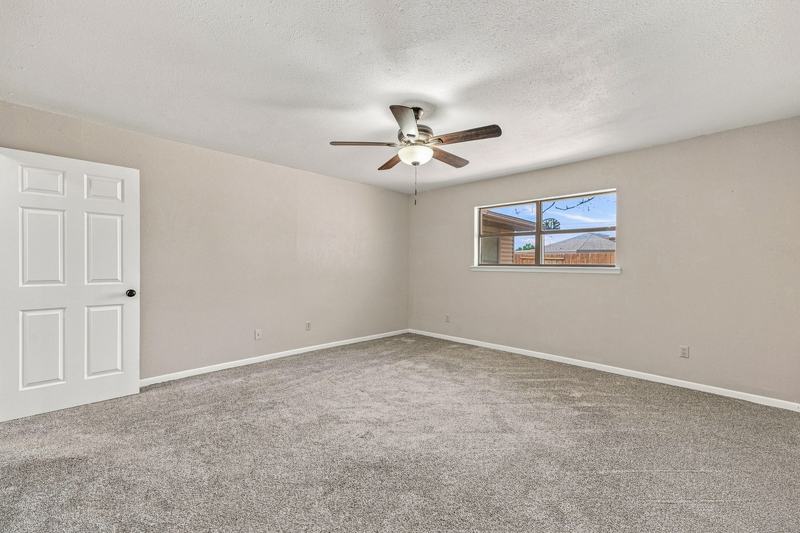 Carpeted bedroom with ceiling fan and window