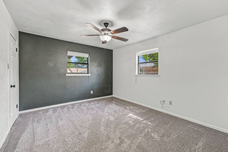 Bedroom with a dark accent wall and ceiling fan