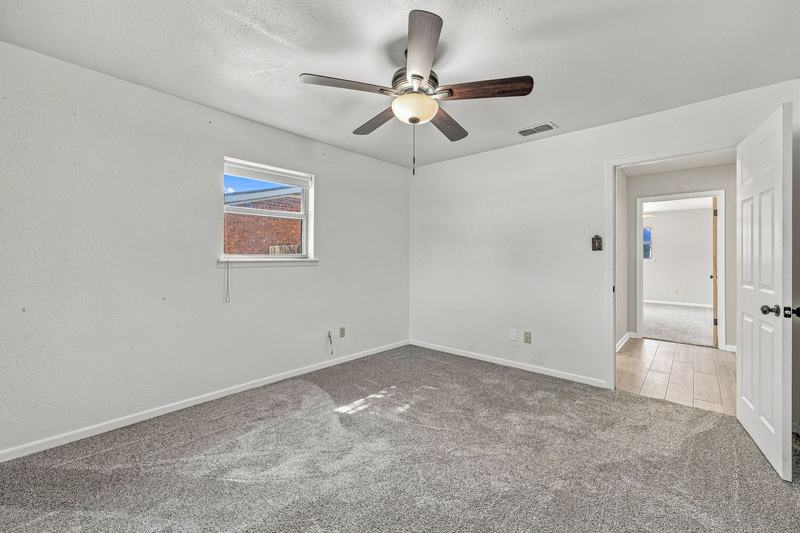 Carpeted bedroom with ceiling fan and window