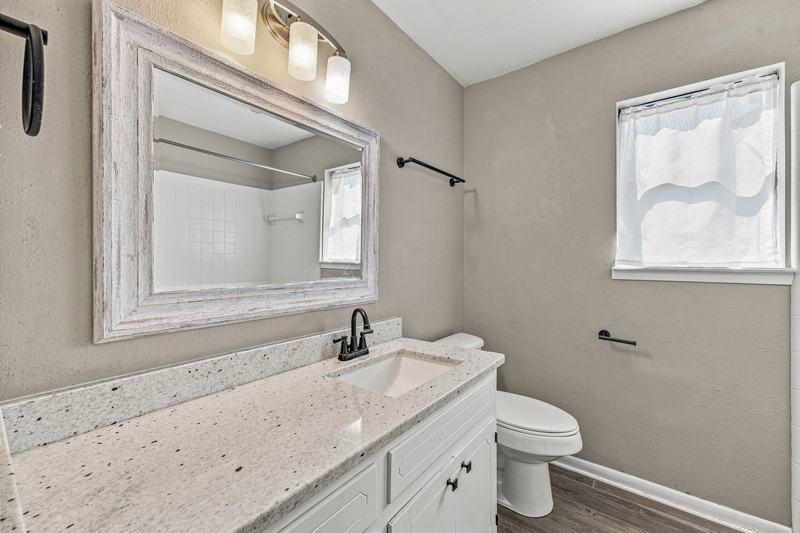 Second bathroom with a single vanity and framed mirror