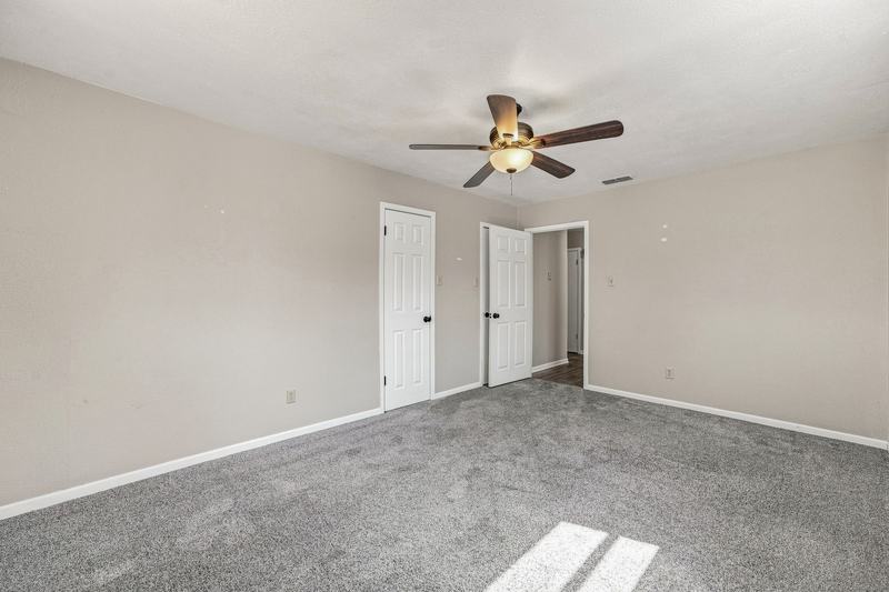 Carpeted bedroom with ceiling fan and closet