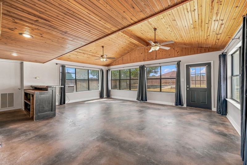 Bonus sunroom with a wood-paneled vaulted ceiling and walls of windows
